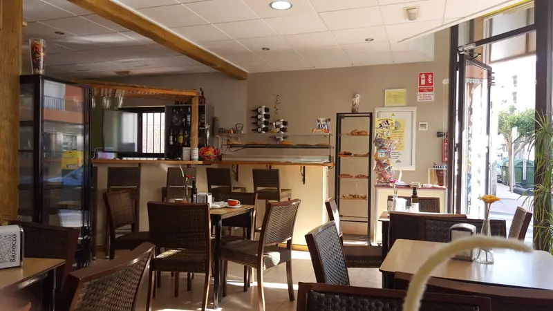 Interior de la cafetería Tía Tota con la barra y las mesas por la mañana