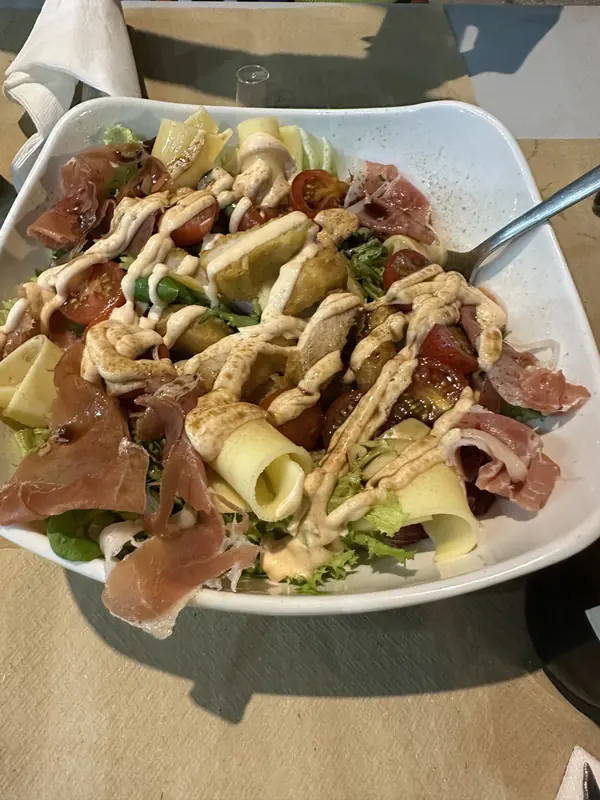 Ensalada con jamón serrano, escamas de queso y salsa rosa