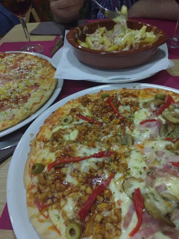 Pizza familiar cargada de ingredientes con tiras de pimiento rojo